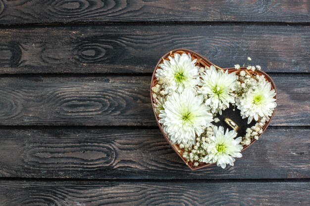 Top view valentines day present flowers and ring inside heart shaped box on wooden rustic desk love gift feeling couple marrriage