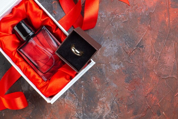 Вид сверху день святого валентина настоящий аромат на темной поверхности подарок духи цвет любви пара женщина кольцо брак