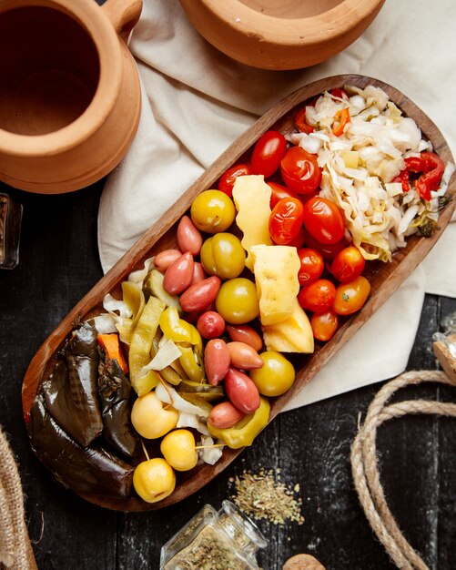 Top view variety of pickles cucumbers tomatoes cabbage on a plate