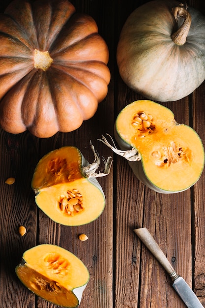 Free photo top view variety of pumpkins on wooden background and knife