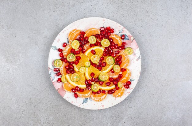 Top view of various kinds of fruit slices on plate.