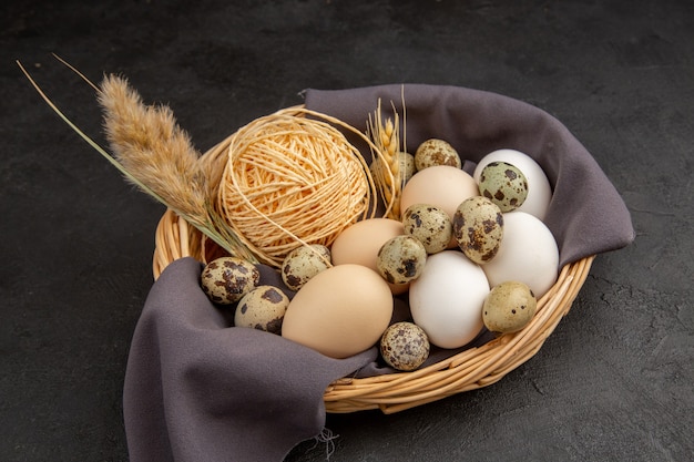 Top view of various organic eggs rope spike on a black towel in a basket on dark background