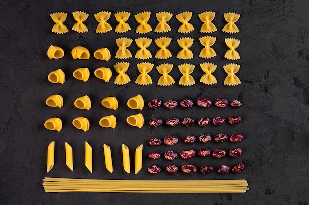 Free photo top view of various raw pasta with kidney beans arranged on black