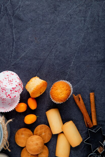 Вид сверху различных видов сладкого печенья и кексов на сером фоне с копией пространства