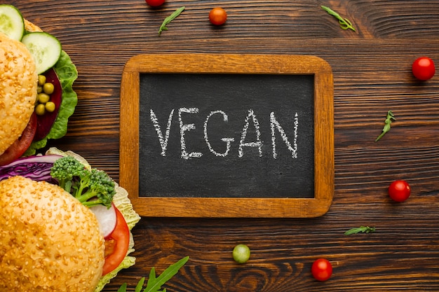 Free photo top view vegan lettering on chalkboard with wooden background