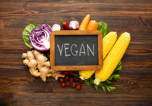 Top view vegetable arrangement with vegan lettering on chalkboard 