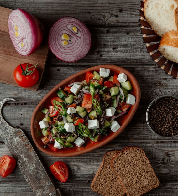 Top view vegetable cheese salad in a pottery bowl