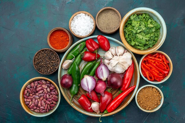 Top view vegetable compoisition onions garlics greens and peppers on the dark desk vegetable food meal salad color photo