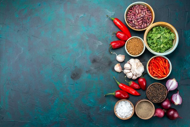 Top view vegetable composition onions garlics peppers greens on the dark background seasoning pepper food product color