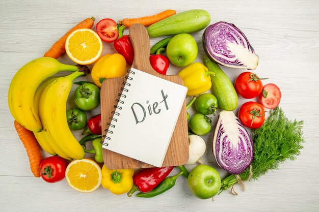 Top view vegetable composition tomatoes cabbage bell-peppers with bananas on white background