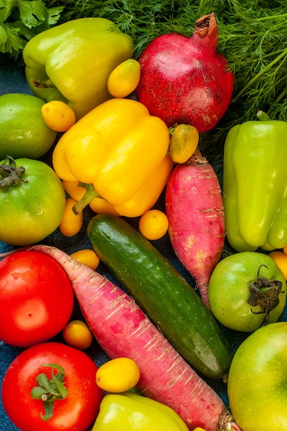 Вид сверху овощной композиции со свежими фруктами на синем столе
