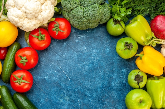 青いテーブルの上の新鮮な果物と野菜の組成の上面図