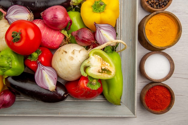 Top view vegetable composition with seasonings on white table