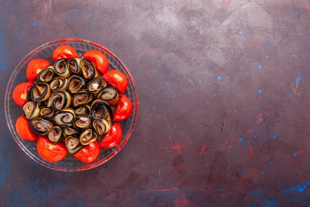 Top view vegetable meal sliced and rolled tomatoes with eggplants on dark background