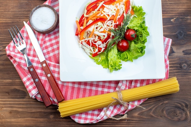 Top view vegetable salad on brown surface