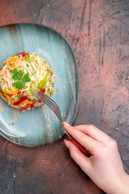 Top view vegetable salad round shaped inside plate on dark table