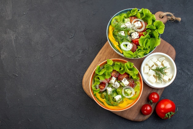 Free photo top view vegetable salad with cheese cucumbers and tomatoes on dark background