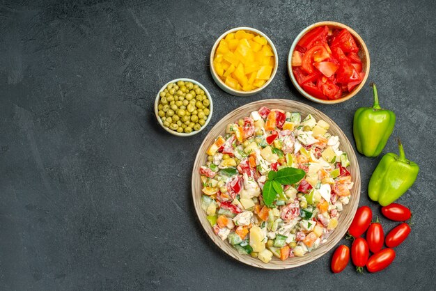 Top view of vegetable salad with different vegetables on side with free space for text on the left side on the grey background
