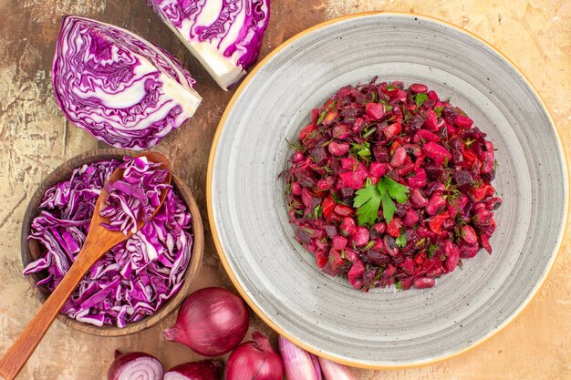 Top view vegetable salad with parsley leaves on top on a ceramic plate with chopped red cabbage and onions on a wooden background