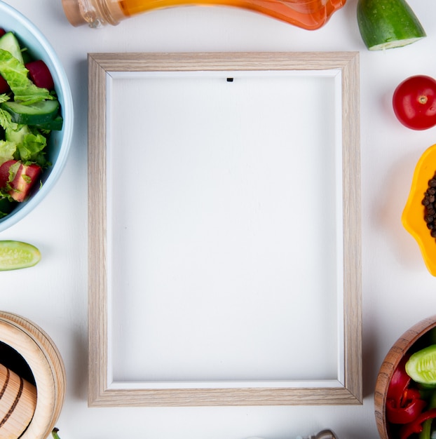 Free photo top view of vegetable salads and vegetables as cucumber tomato with black pepper melted butter and frame on white surface with copy space