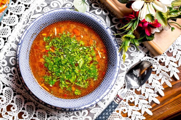 Top view of vegetable soup bowl garnished with herbs