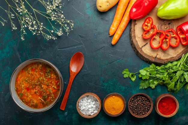 Top view vegetable soup with fresh vegetables and seasonings on dark-green surface ingredient soup meal food vegetable