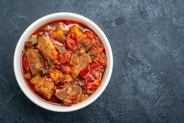 Top view vegetable soup with meat inside plate on a grey