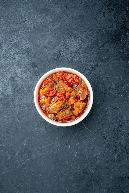 Top view vegetable soup with meat inside plate on grey