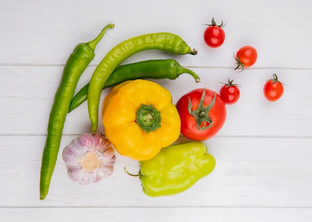 Top view of vegetables as pepper garlic tomato on wooden surface