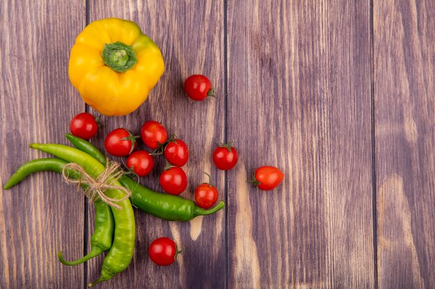 Top view of vegetables as pepper and tomato on wooden surface