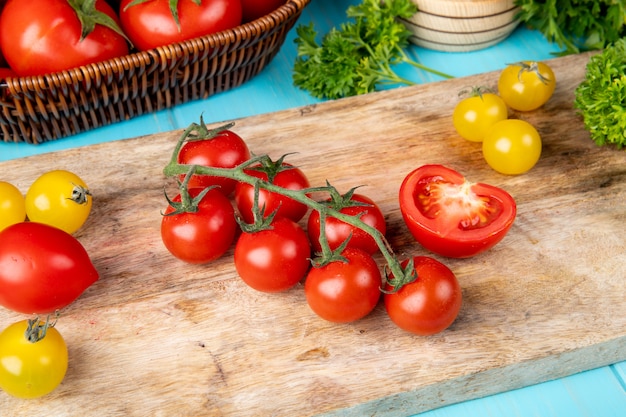 青い表面にニンニククラッシャートマトとまな板の上のトマトコリアンダーとして野菜のトップビュー