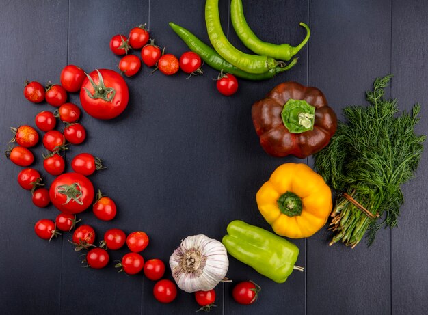 Top view of vegetables as tomato pepper garlic dill set in round shape on black surface