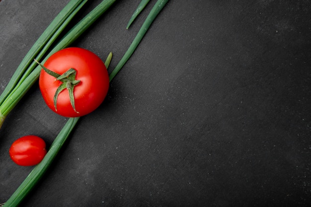 검은 표면에 왼쪽에 토마토와 scallions로 야채의 상위 뷰