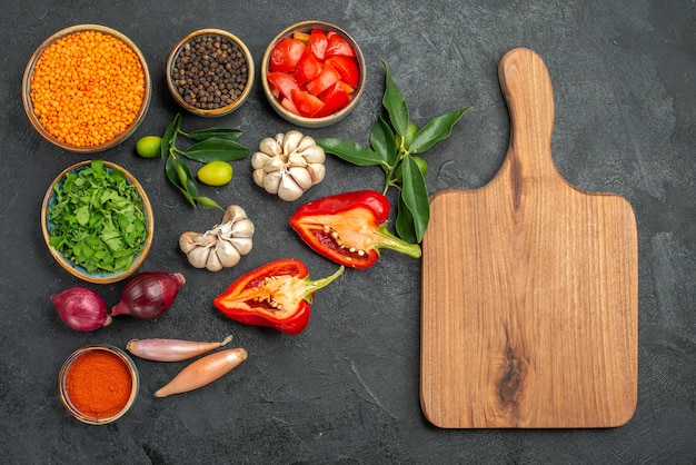 Top view of vegetables bowl of lentil herbs spices tomatoes bell pepper the cutting board