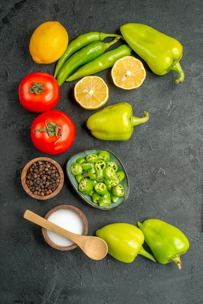 暗い背景にトップビュー野菜組成トマトピーマンとレモン