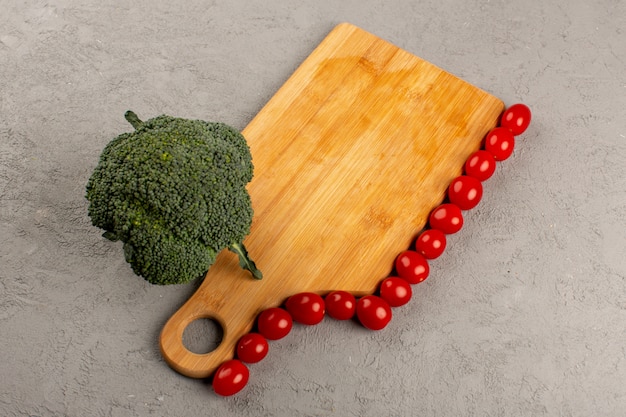 top view vegetables fresh green broccoli and red cherry tomatoes on the grey desk