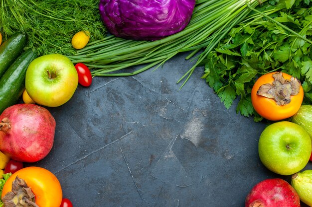 Top view vegetables and fruits cucumber dill cherry tomatoes red cabbage pomegranate persimmon apple free space