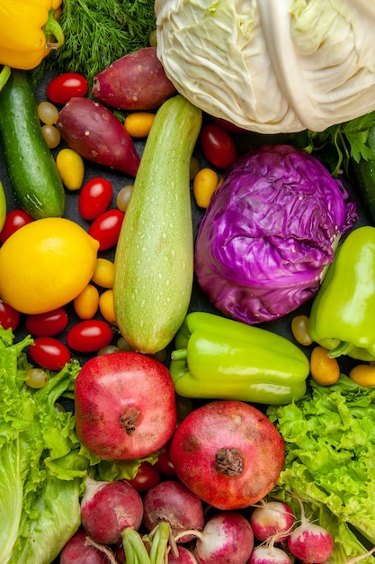 Free photo top view vegetables and fruits zucchini bell peppers cherry tomatoes cumcuat red and white cabbage lemon pomegranates radish lettuce