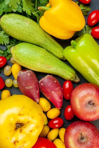 Free photo top view vegetables and fruits zucchini yellow bell pepper apples quince cherry tomatoes cumcuat parsley