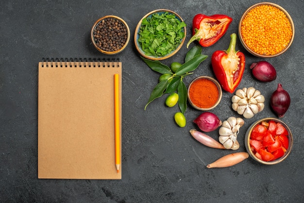 Top view of vegetables herbs lentil vegetables spices citrus fruits notebook pencil