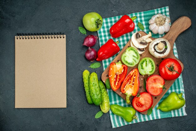 Top view vegetables mushrooms tomatoes bell peppers on cutting board