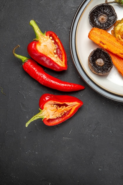 Top view of vegetables plate of roasted vegetables red tablecloth bell peppers hot pepper