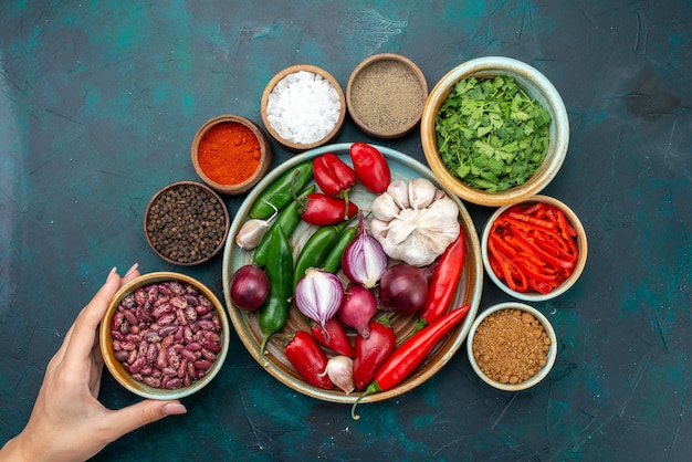 Free photo top view vegetables and seasonings with beans peppers on the dark table vegetable food meal salad