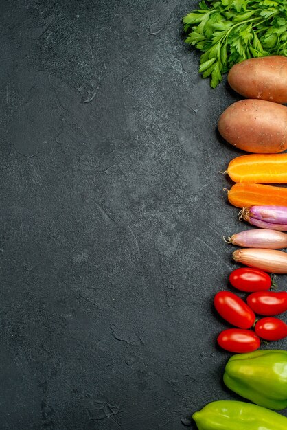 濃い灰色がかった緑色の背景にあなたのテキストのための自由な場所がある側の野菜の上面図