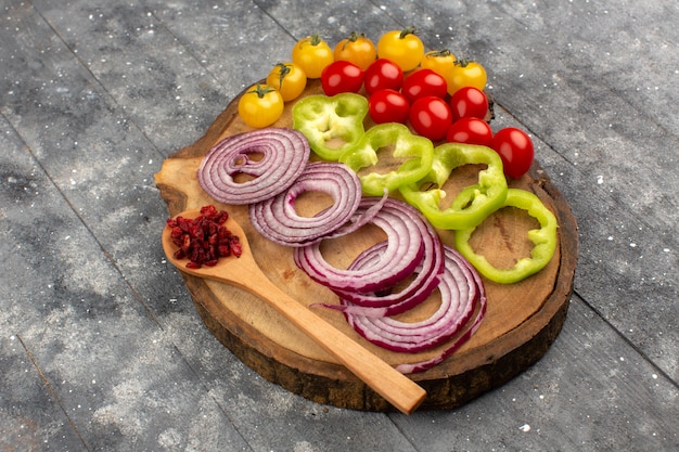 top view vegetables sliced and whole on the brown desk and grey floor