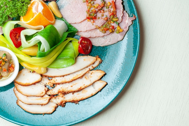 Top view of vegetables and spiced meat on blue plate