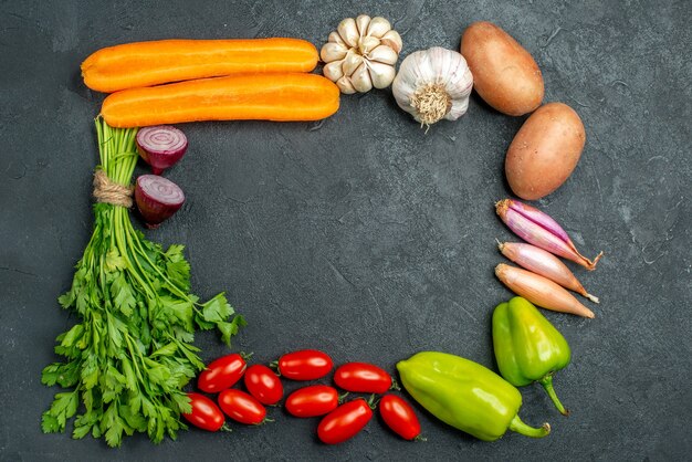 Top view of vegetables in square and with free place for your text in the center on dark grey background