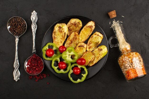 top view vegetables such as cooked eggplants fresh green bell peppers and red cherry tomatoes inside black plate