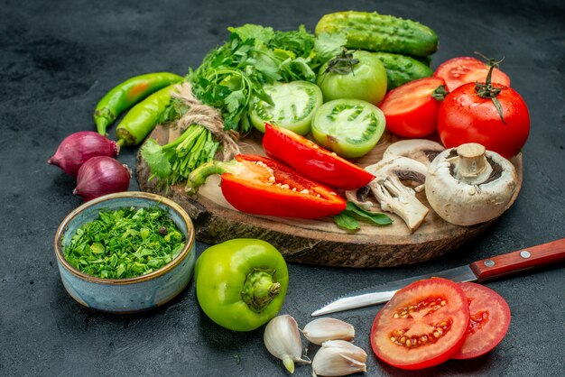 Top view vegetables tomatoes bell peppers cucumber greens mushroom on wood board