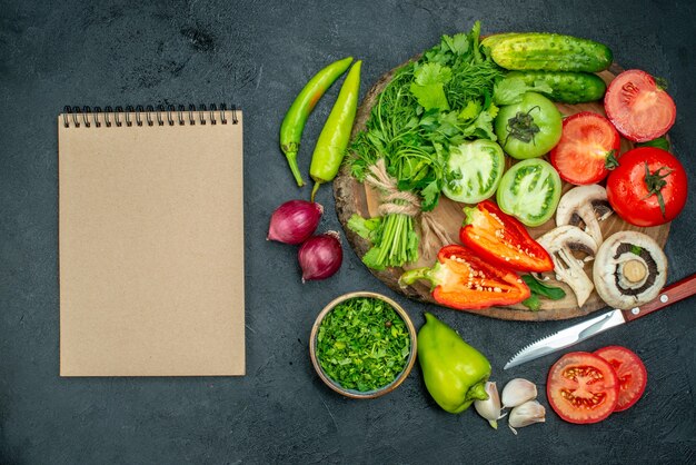 Top view vegetables tomatoes bell peppers cucumber greens mushroom on wood board